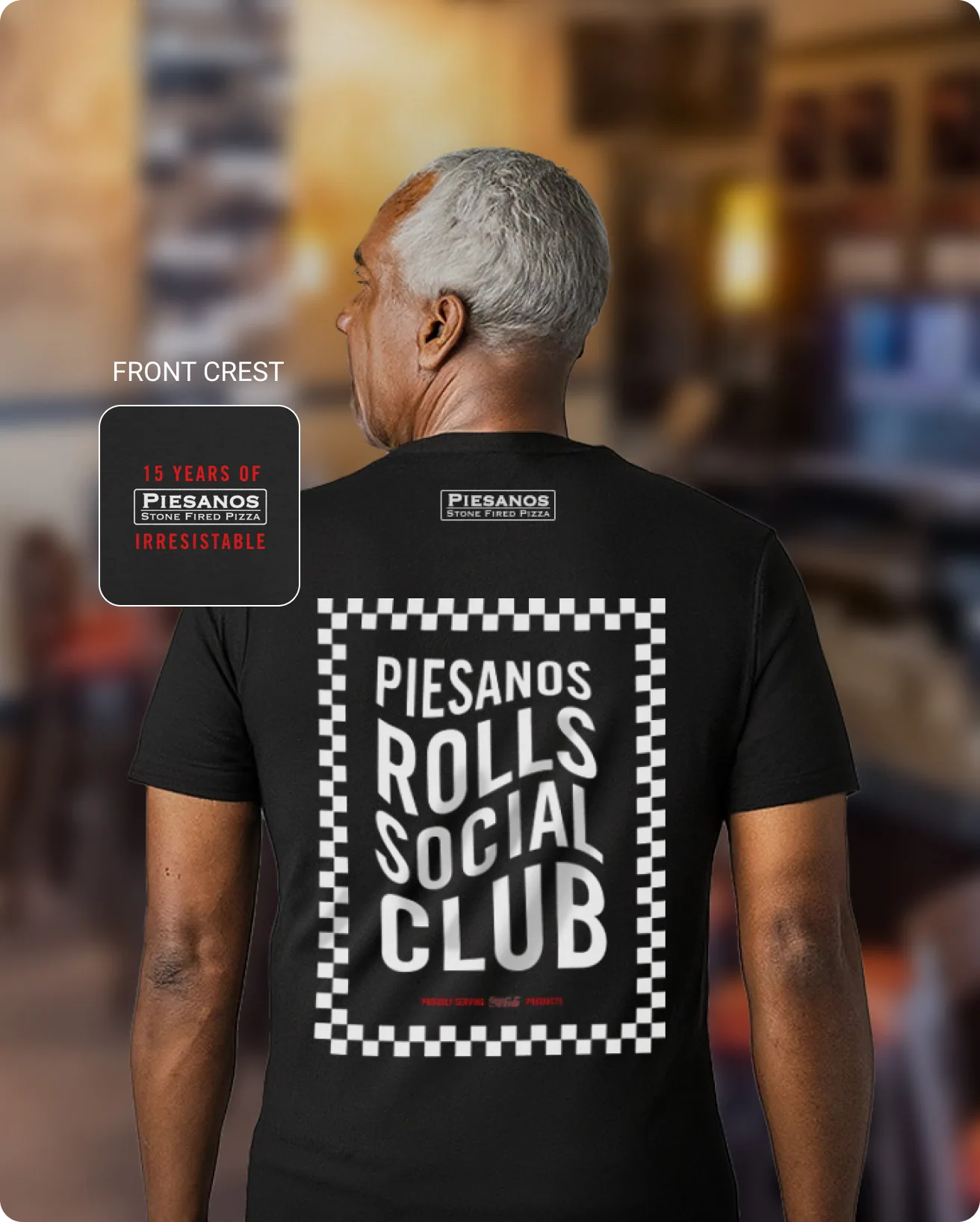 Man in a black t-shirt emblazoned with the phrase 'PIESANOS ROLLS SOCIAL CLUB'