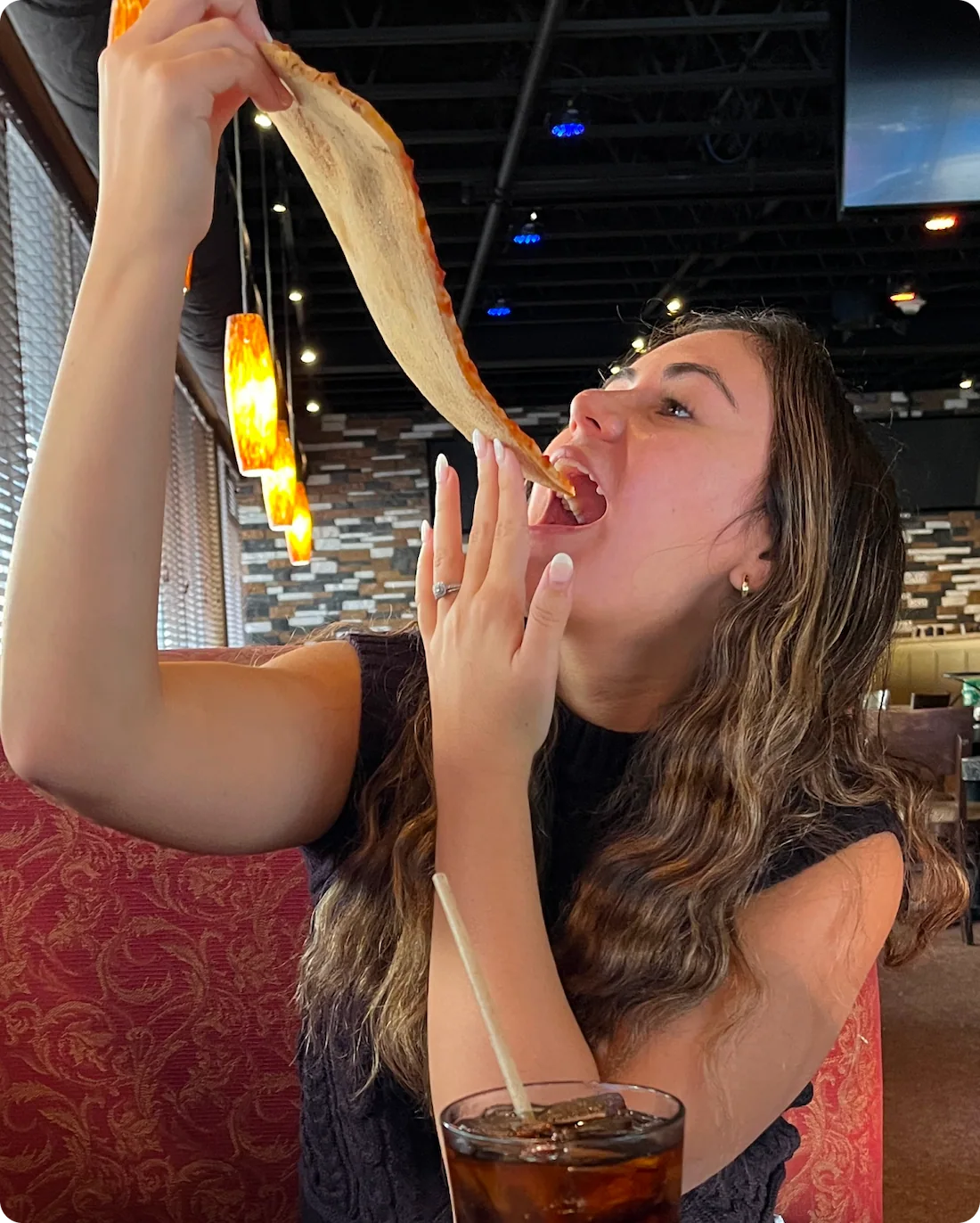 A young woman enjoying a large slice of our limited-edition Lasagna Pizza